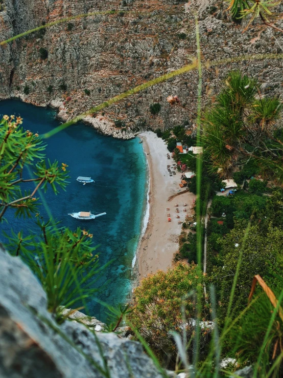 a view of some boats anchored on the shore and the mountains