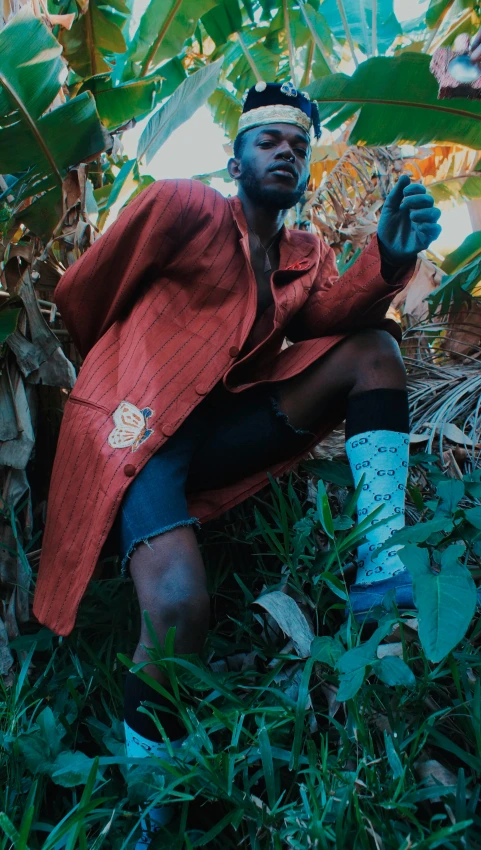 a man sitting in the grass and holding his hand up