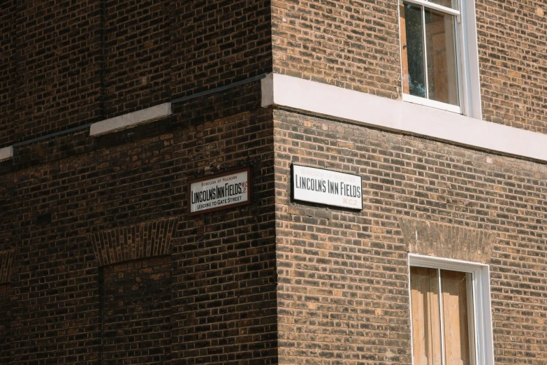 a brick building with a street sign hanging off the side