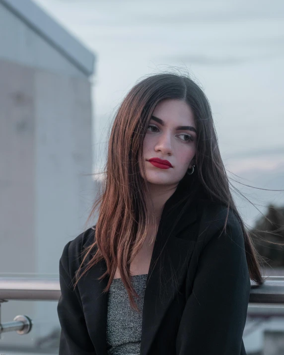 woman in a suit sitting on a balcony