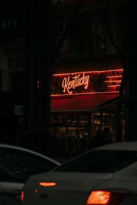 a lighted red sign reading kentucky hangs from the side of a building