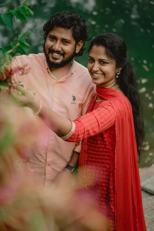 couple posing for po near green water on  sunny day