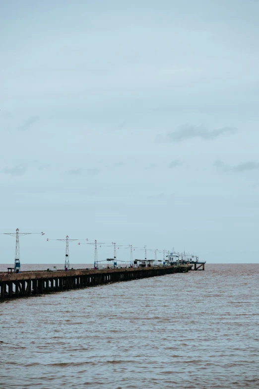 there are several cranes standing on the pier