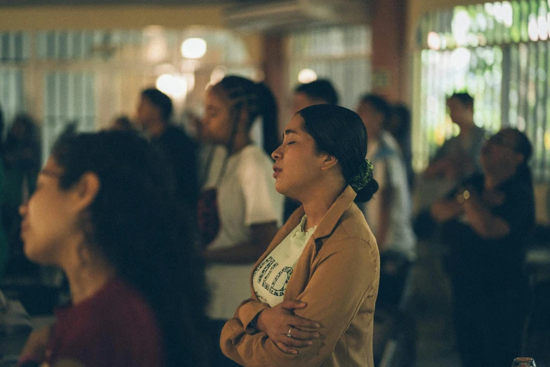 a woman standing with her arms crossed looking at others