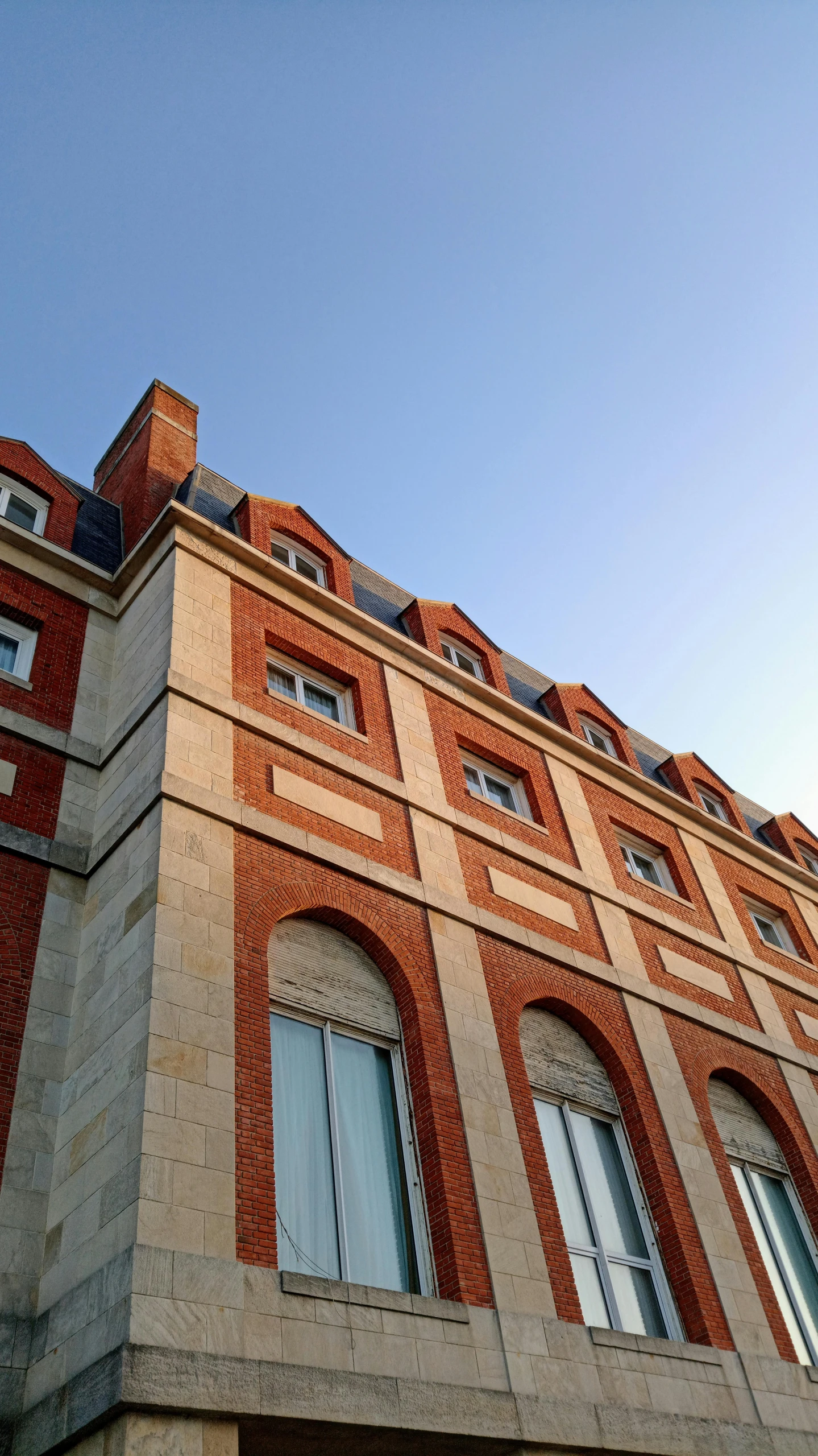 a tall brick building with a clock on the front