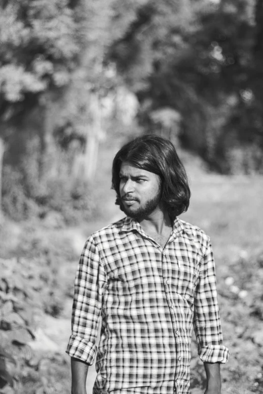 black and white po of a man standing near a tree