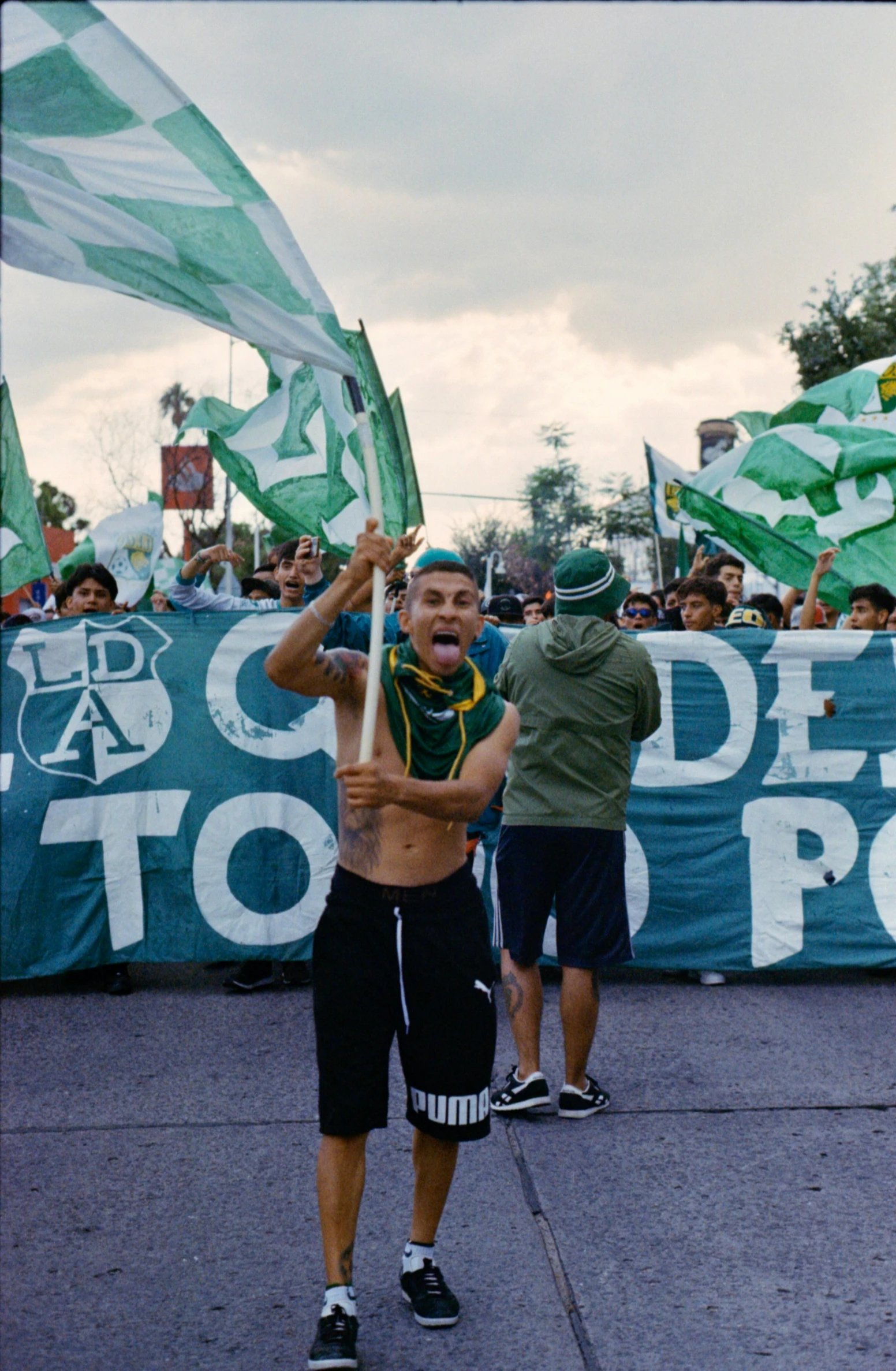 a man is walking through the street holding flags