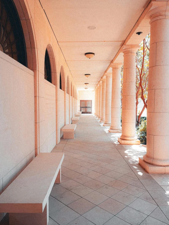 the interior walkway of a building, with many white benches