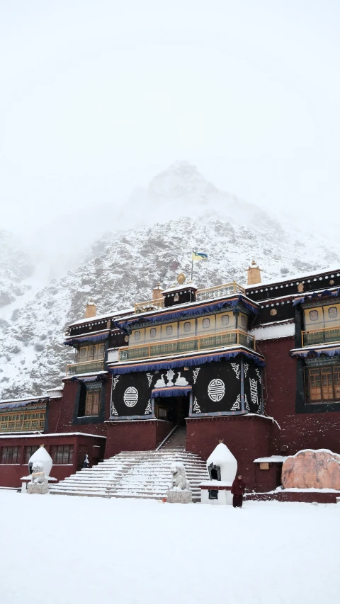 a building with clock faces on the outside of it in the snow