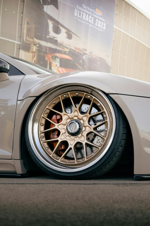 the rim of an interesting car, parked in front of a building