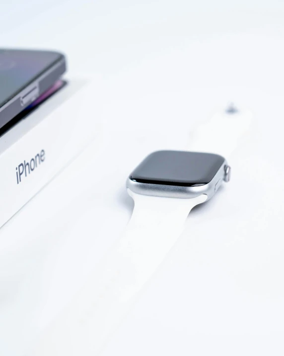 apple watch and box on white table with apple logo