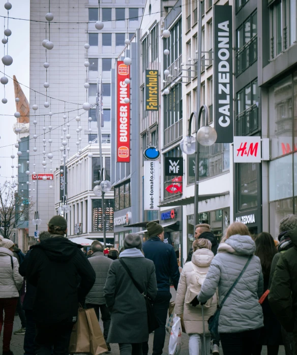 group of people walk down the street in downtown