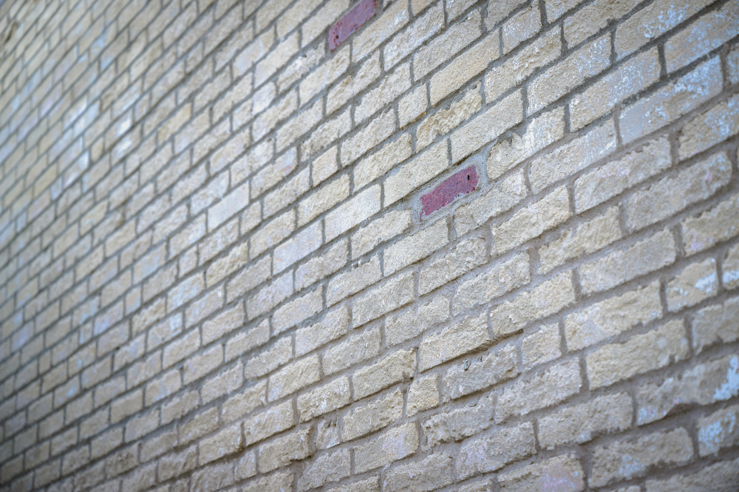 a brick wall with red and grey markings