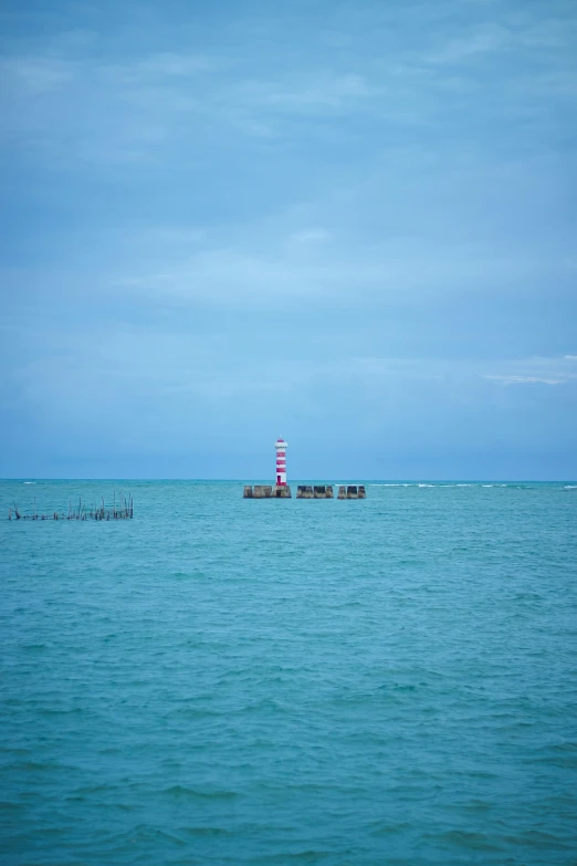 a lighthouse is seen off the side of the ocean