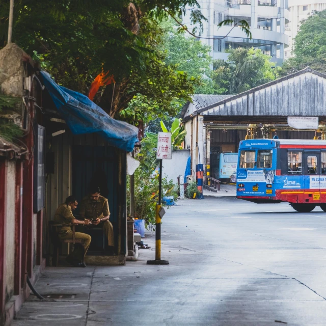 a woman sits in the street by the bus as the train drives past