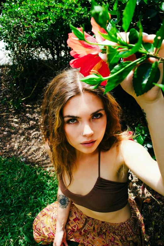 a woman wearing a bikini top and brown skirt