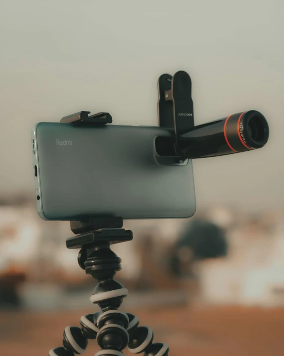 a smartphone is placed on a tripod and being pographed by someone