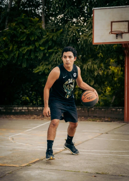 a boy in black basketball outfit holding a basketball