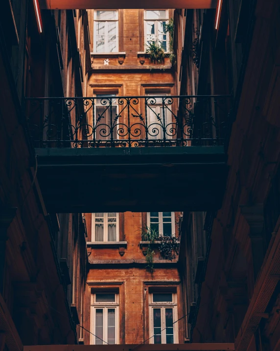 the top of a building looking up at two balcony bars