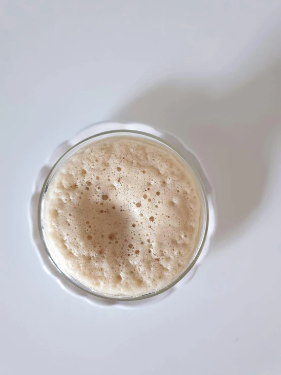 a white surface and a glass filled with liquid