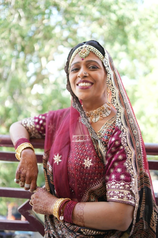 a woman wearing a red and gold headpiece smiles