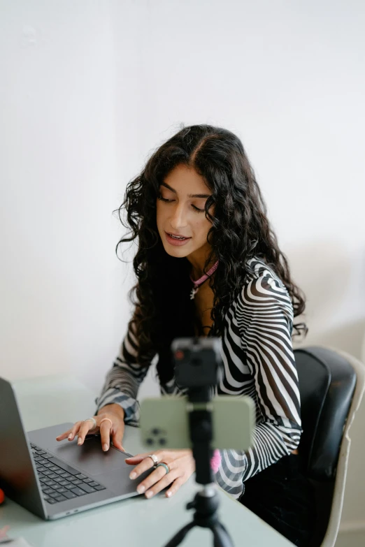 a woman is on her computer at the desk