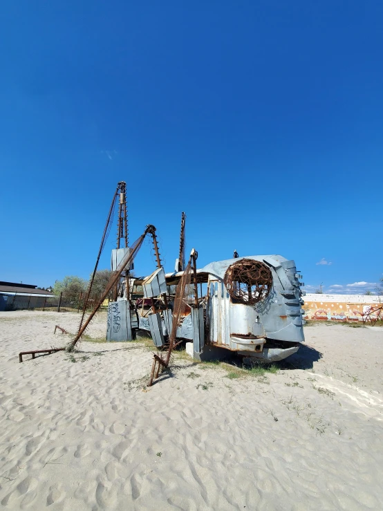 an old rusty boat sitting on top of a sandy beach