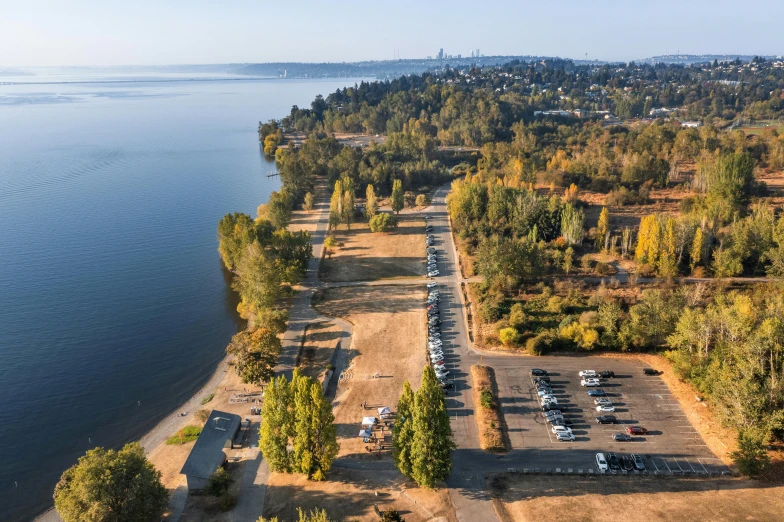 the parking lot in front of a river has a lot of parked cars