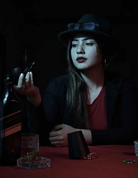 a woman wearing a black hat sitting at a table in a room