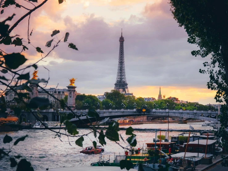 a river and bridge in front of the eiffel tower