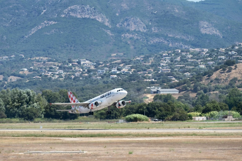 a large air plane flying over a small field