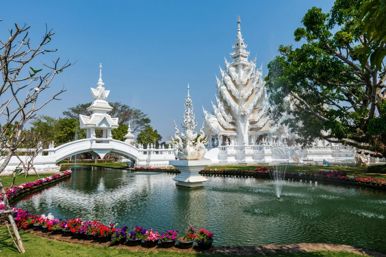 an elaborate white building surrounded by flowers