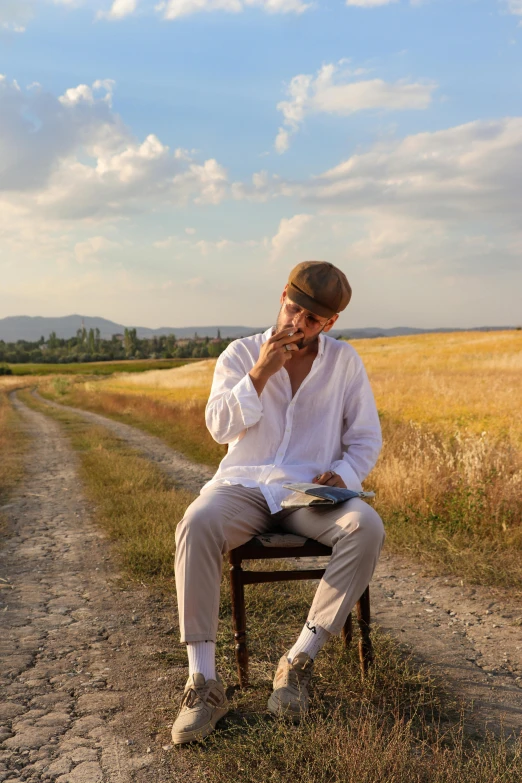 a man sitting on top of a chair while talking on a cell phone