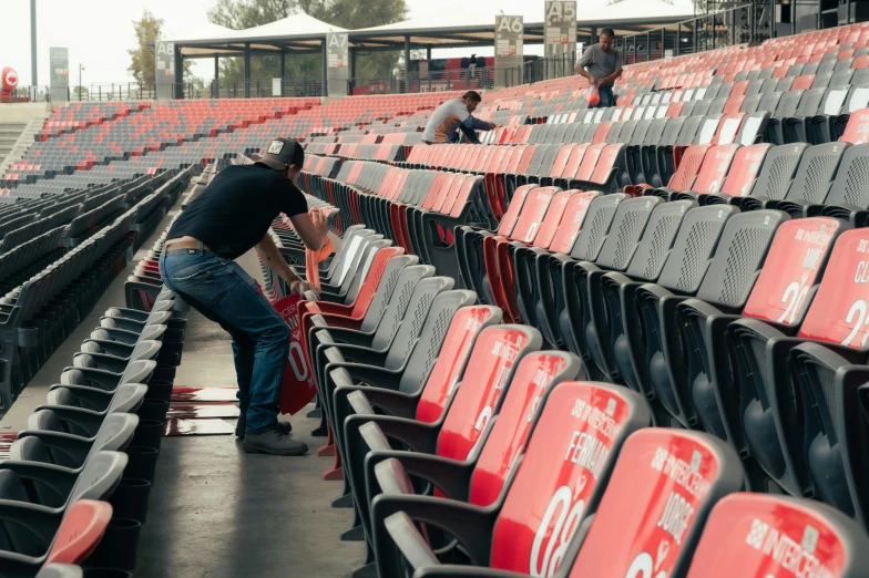 a man puts his pants up on a stadium bleacher