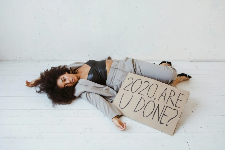 woman lying on the floor with a sign saying how much cares do i