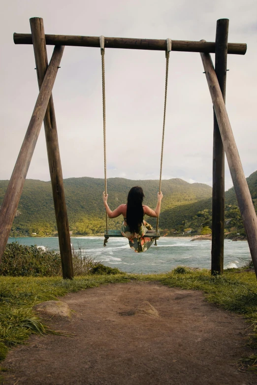 the woman is swinging on the swings in the field