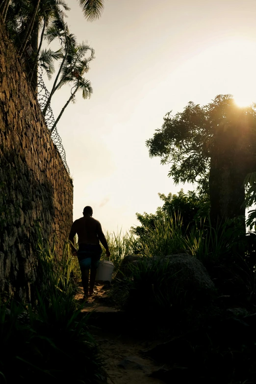 the person walks up the trail towards the setting sun