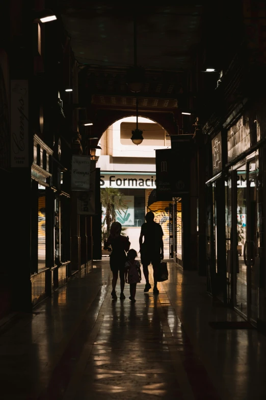 people walk through a large building at night