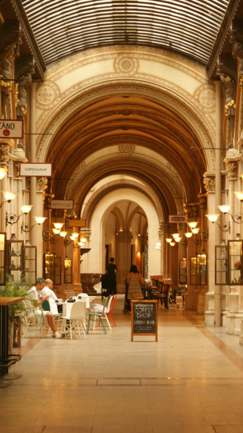 a large indoor area with tables, chairs and lamps