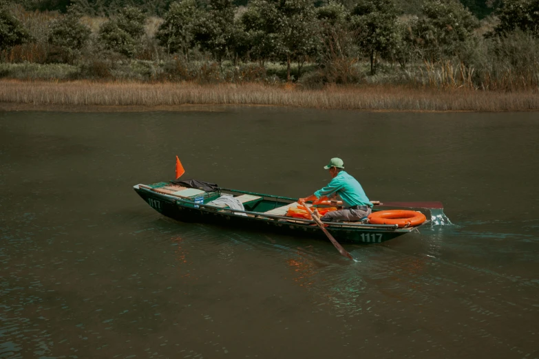 a man sits in a row boat on a lake