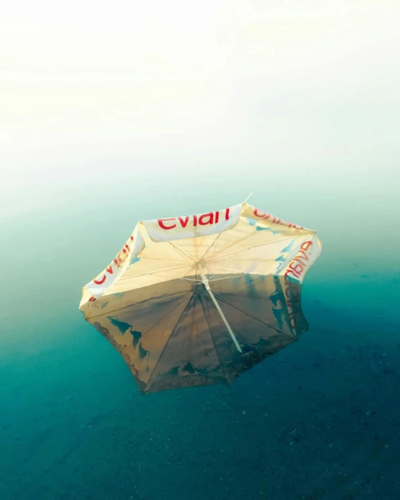 an umbrella floating on water in the middle of the ocean