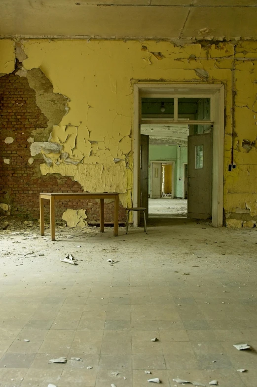 an old room with broken walls, two benches and an open doorway