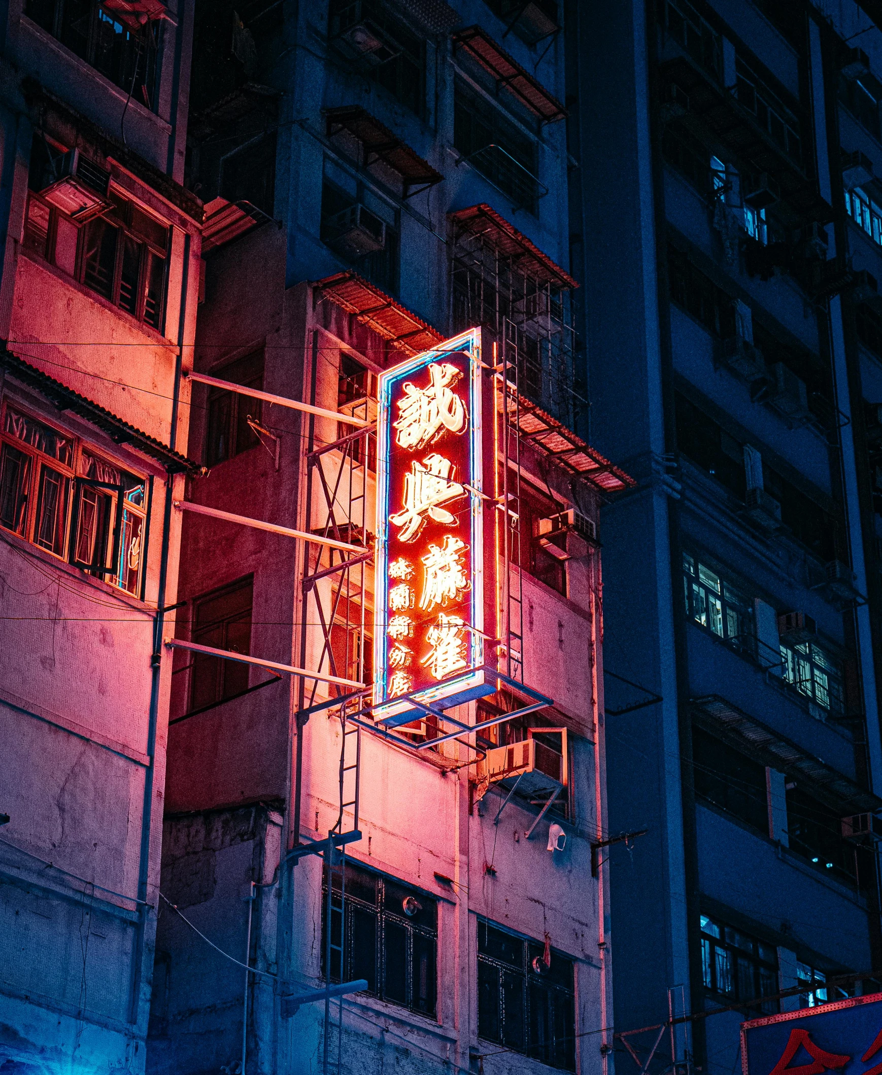 a city building with a neon sign in the middle