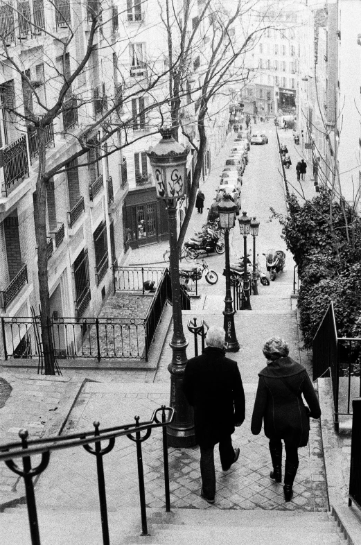 two people walking up a steeply made street in the snow