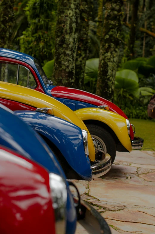 old cars lined up on the sidewalk in the middle of the street