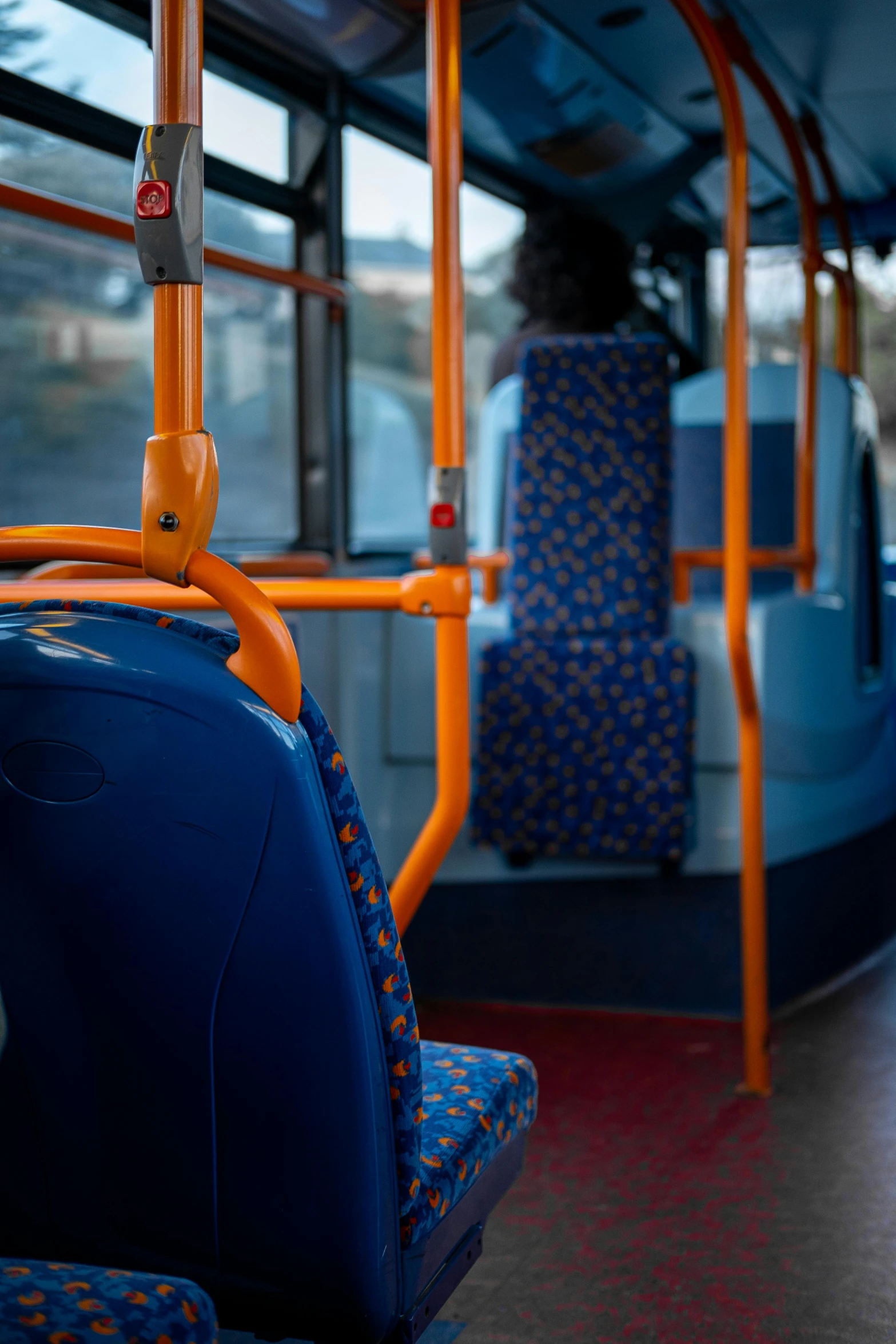 a yellow orange blue and white seat and interior of a bus