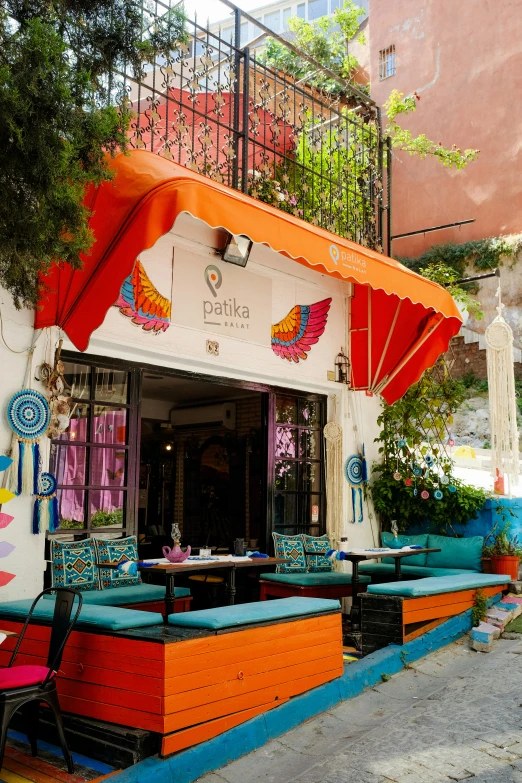 an outside cafe with several colorful booths and umbrellas