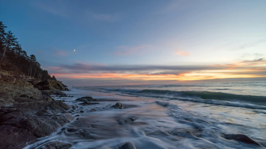 a sunset at a beach with crashing waves