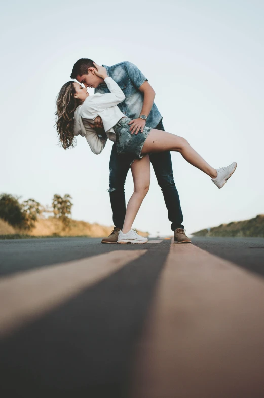 a man is kissing a woman's head in a street