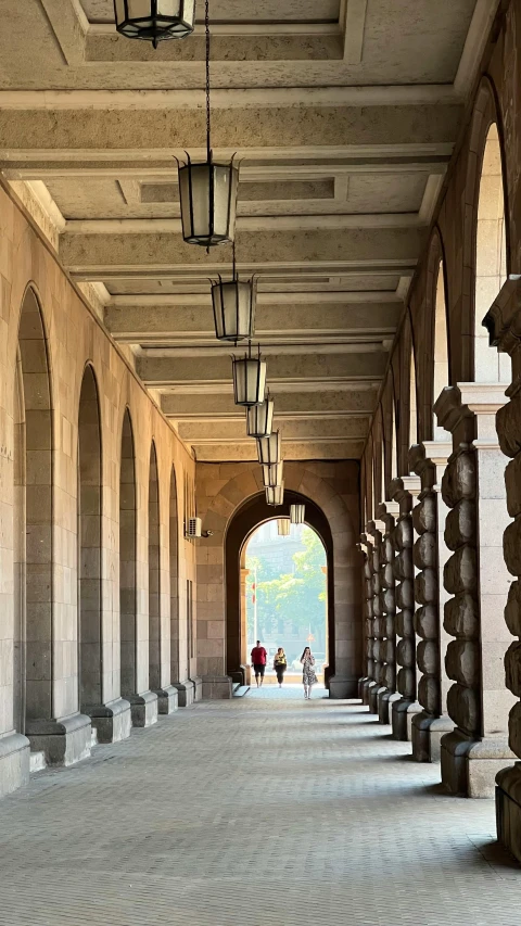 the walkway to a building with columns and lanterns